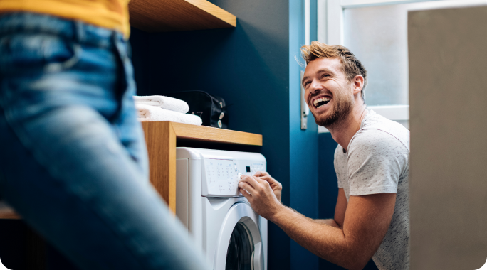 Hombre sonriendo poniendo una lavadora