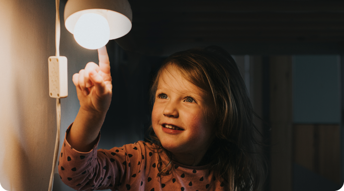 Una niña con una lámpara de bajo consumo