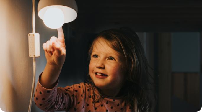 Una niña con una lámpara de bajo consumo