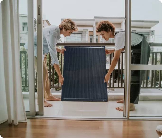 Dos personas instalando un kit solar en su terraza